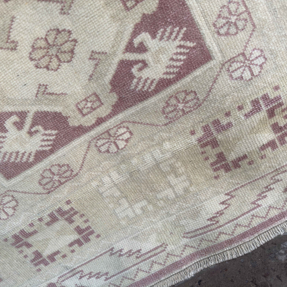 Close-up of the beige vintage turkish rug showing neutral details, hand-knotted weave, wool and cotton and low pile.