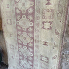 Beige 4' x 6' vintage turkish rug in wool and cotton, shown on the floor.