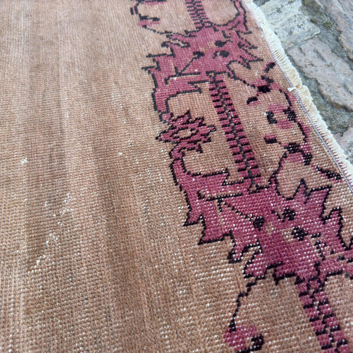 Close-up of the beige vintage turkish rug showing traditional details, hand-knotted weave, wool and cotton and low pile.
