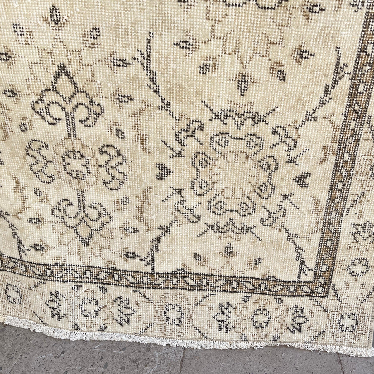 Close-up of the brown vintage turkish rug showing neutral details, hand-knotted weave, wool and cotton and low pile.