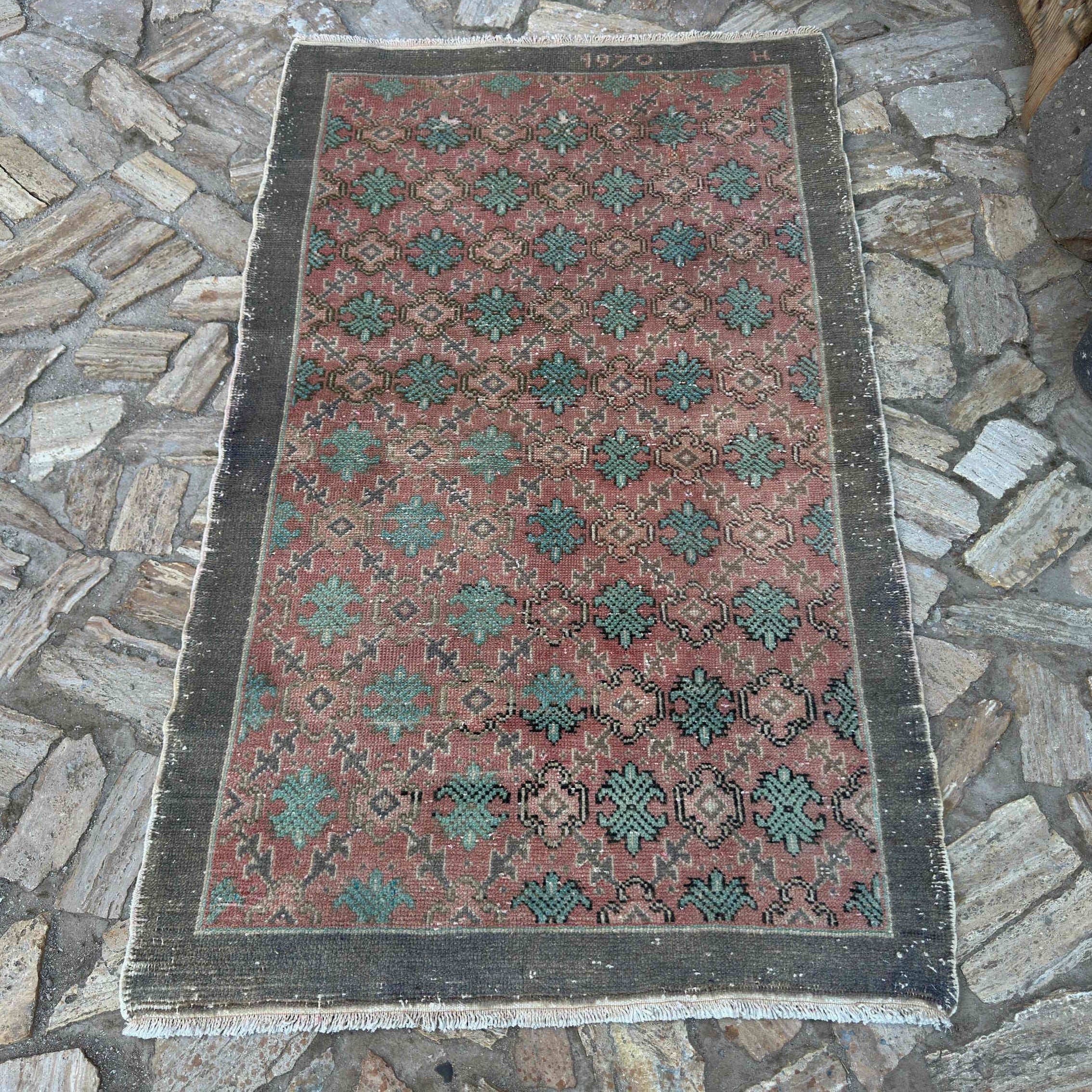 Pale Red 4' x 6' vintage turkish rug in wool and cotton, shown on the floor.