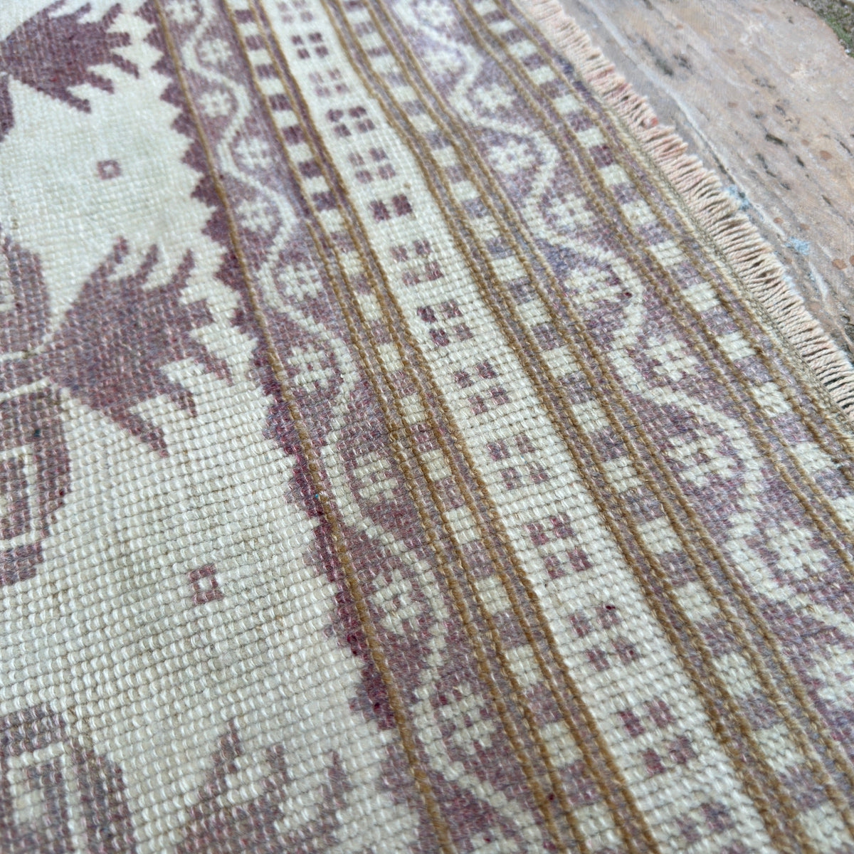 Close-up of the pink vintage turkish rug showing geometric details, hand-knotted weave, wool and cotton and low pile.