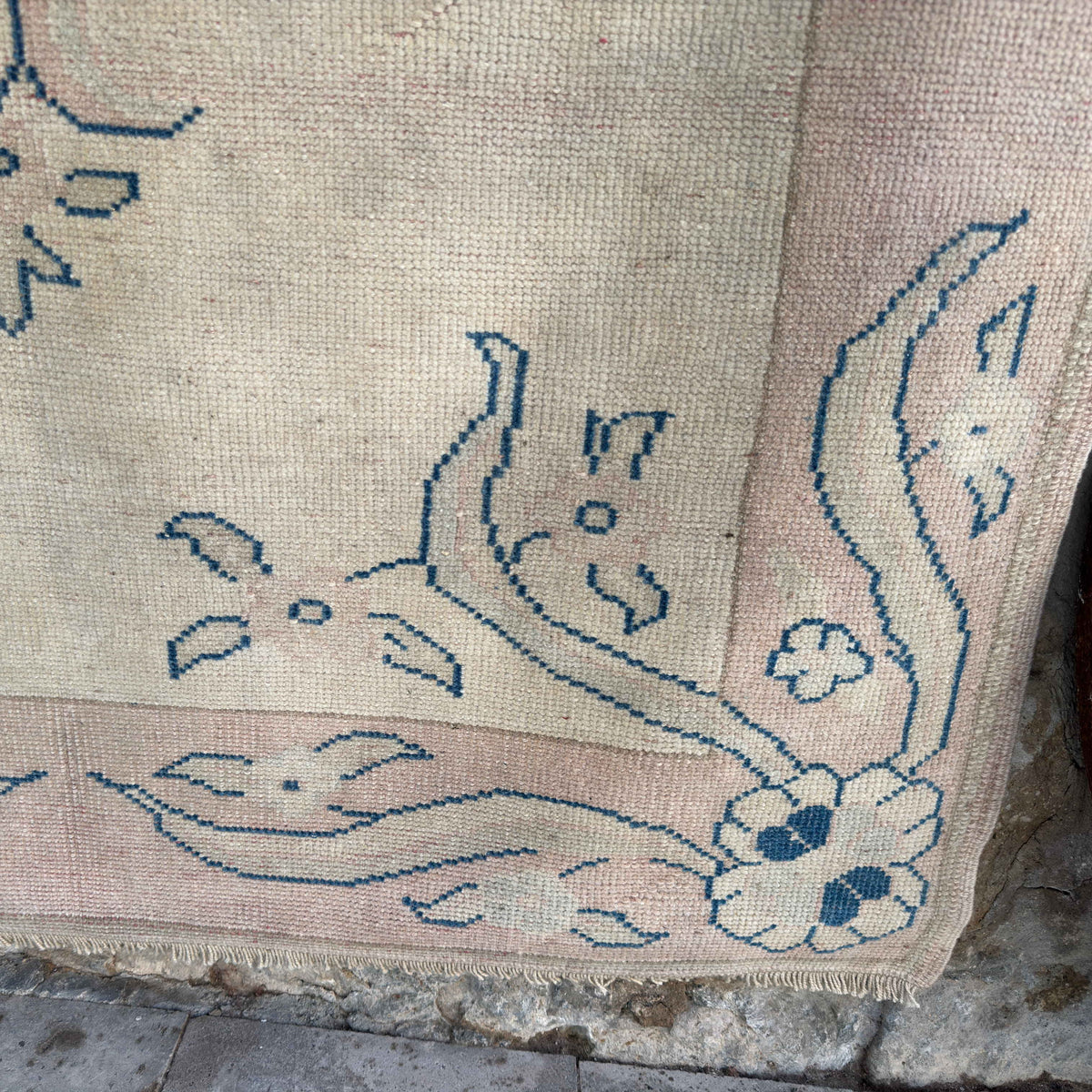 Close-up of the pink vintage turkish rug showing medallion details, hand-knotted weave, wool and cotton and low pile.