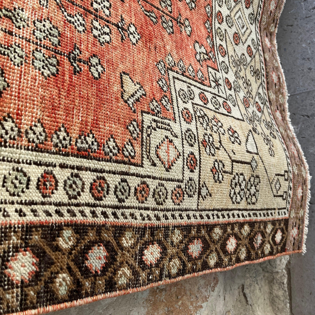 Close-up of the red vintage turkish rug showing traditional details, hand-knotted weave, wool and cotton and low pile.