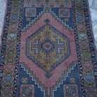 Close-up of the red vintage turkish rug showing traditional details, hand-knotted weave, wool and low pile.