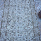 Close-up of the beige vintage turkish rug showing neutral details, hand-knotted weave, wool and cotton and low pile.
