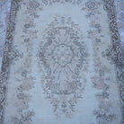 Close-up of the beige vintage turkish rug showing traditional details, hand-knotted weave, wool and cotton and low pile.