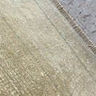 Close-up of the beige vintage turkish rug showing neutral details, hand-knotted weave, wool and cotton and low pile.