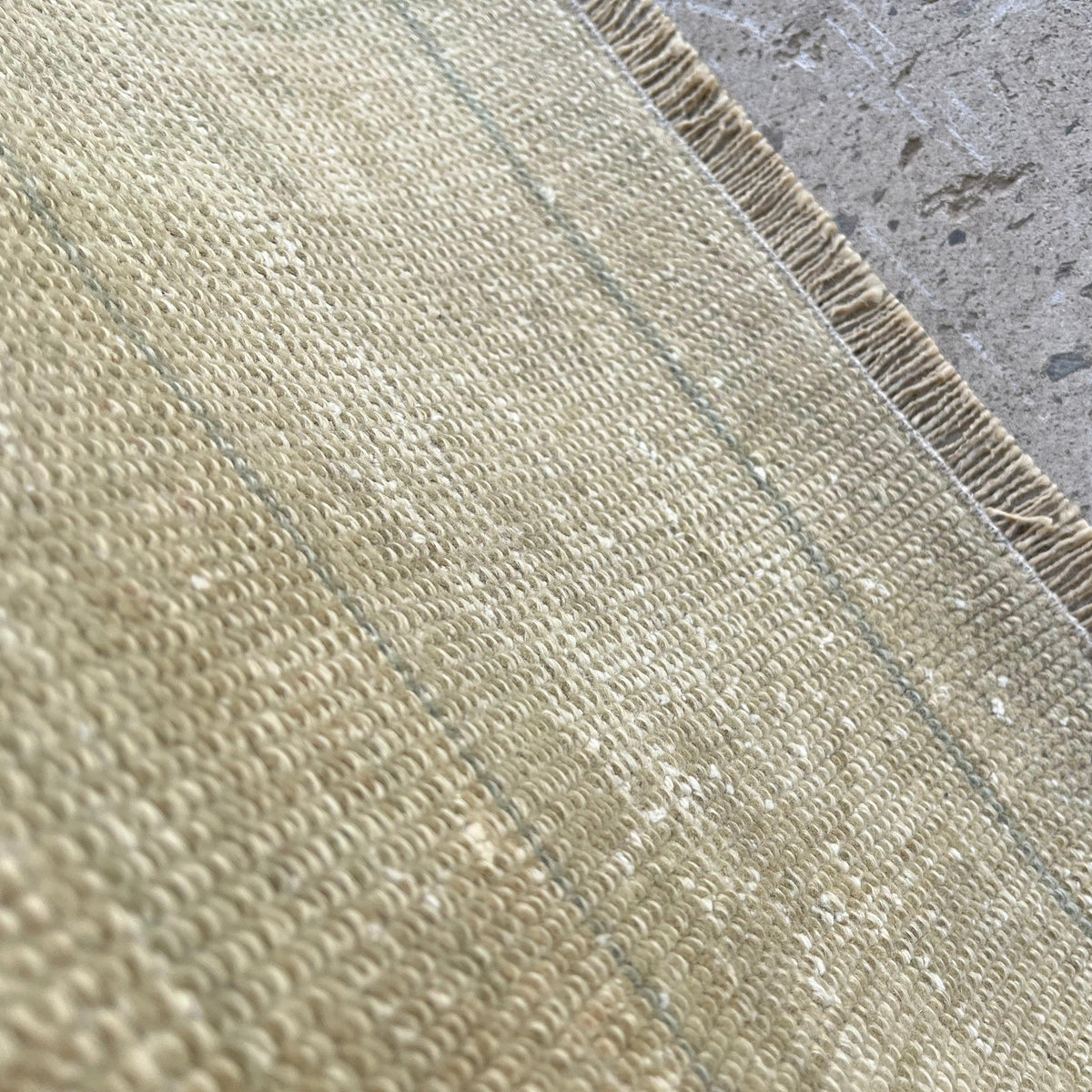 Close-up of the beige vintage turkish rug showing neutral details, hand-knotted weave, wool and cotton and low pile.