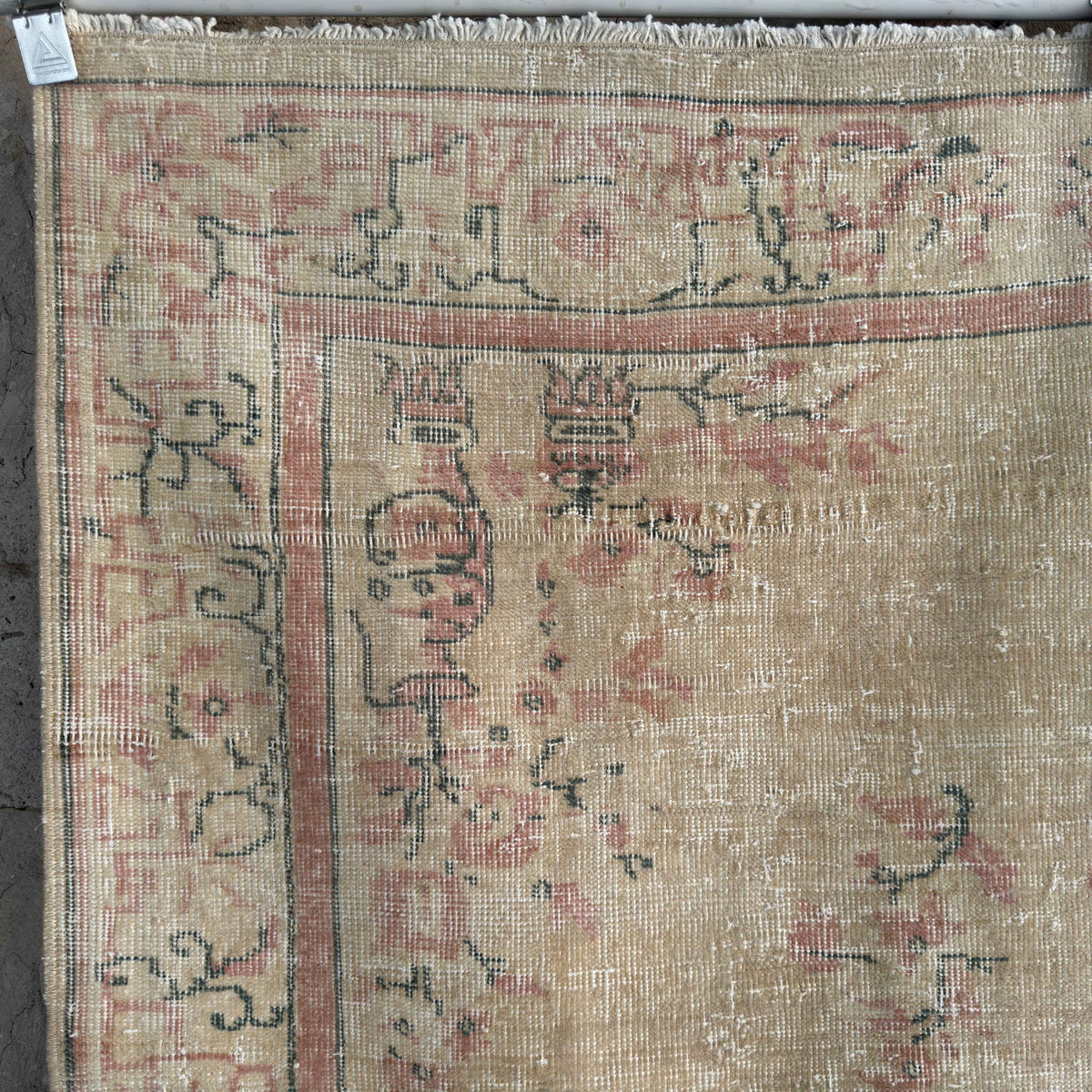 Beige 4' x 7' vintage turkish rug in wool and cotton, shown on the floor.