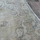 Close-up of the beige vintage turkish rug showing neutral details, hand-knotted weave, wool and cotton and low pile.