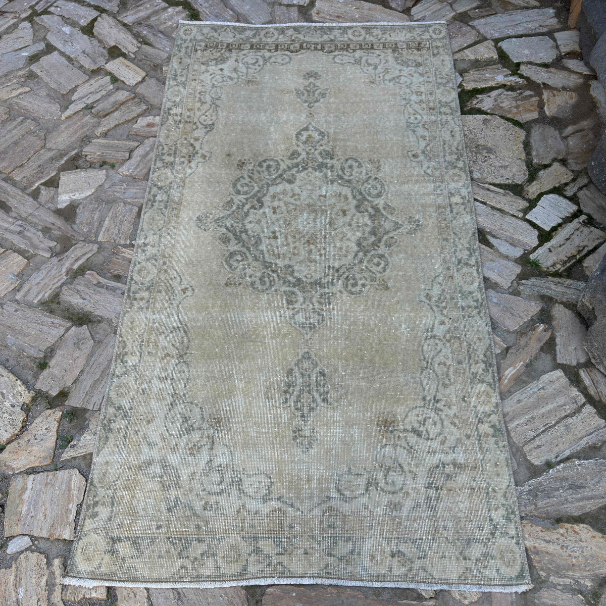 Beige 4' x 7' vintage turkish rug in wool and cotton, shown on the floor.