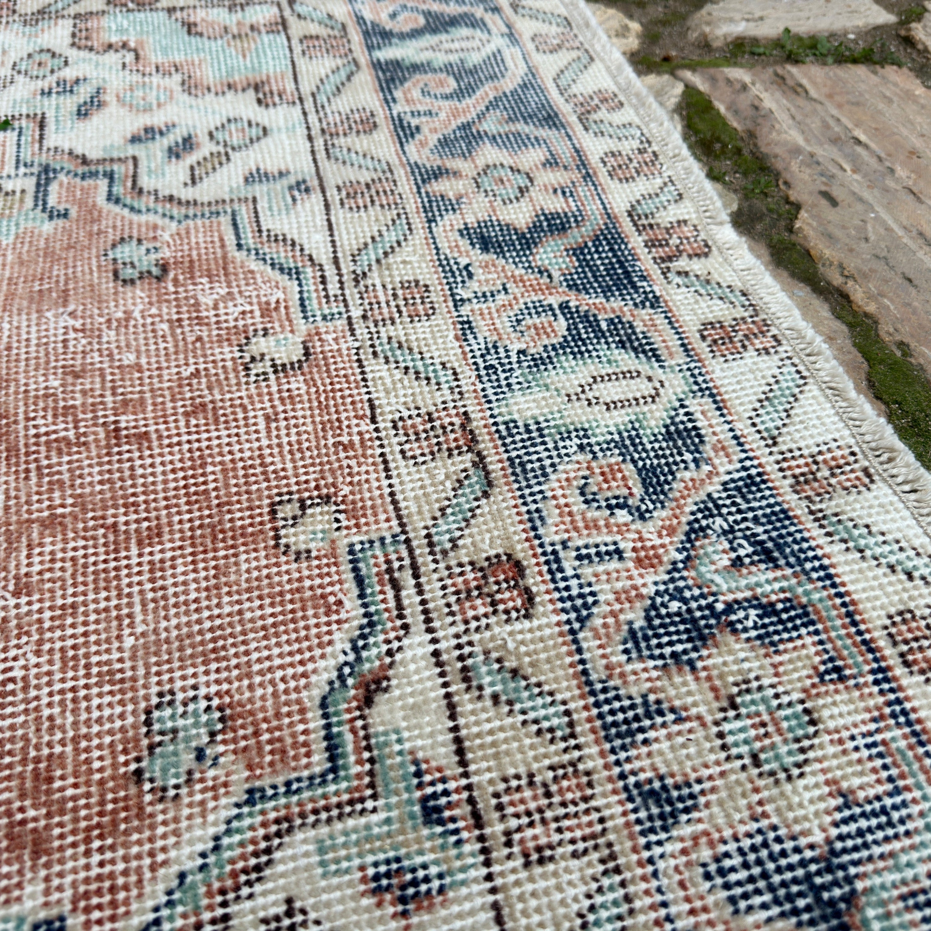 Close-up of the blue vintage turkish rug showing medallion details, hand-knotted weave, wool and cotton and low pile.