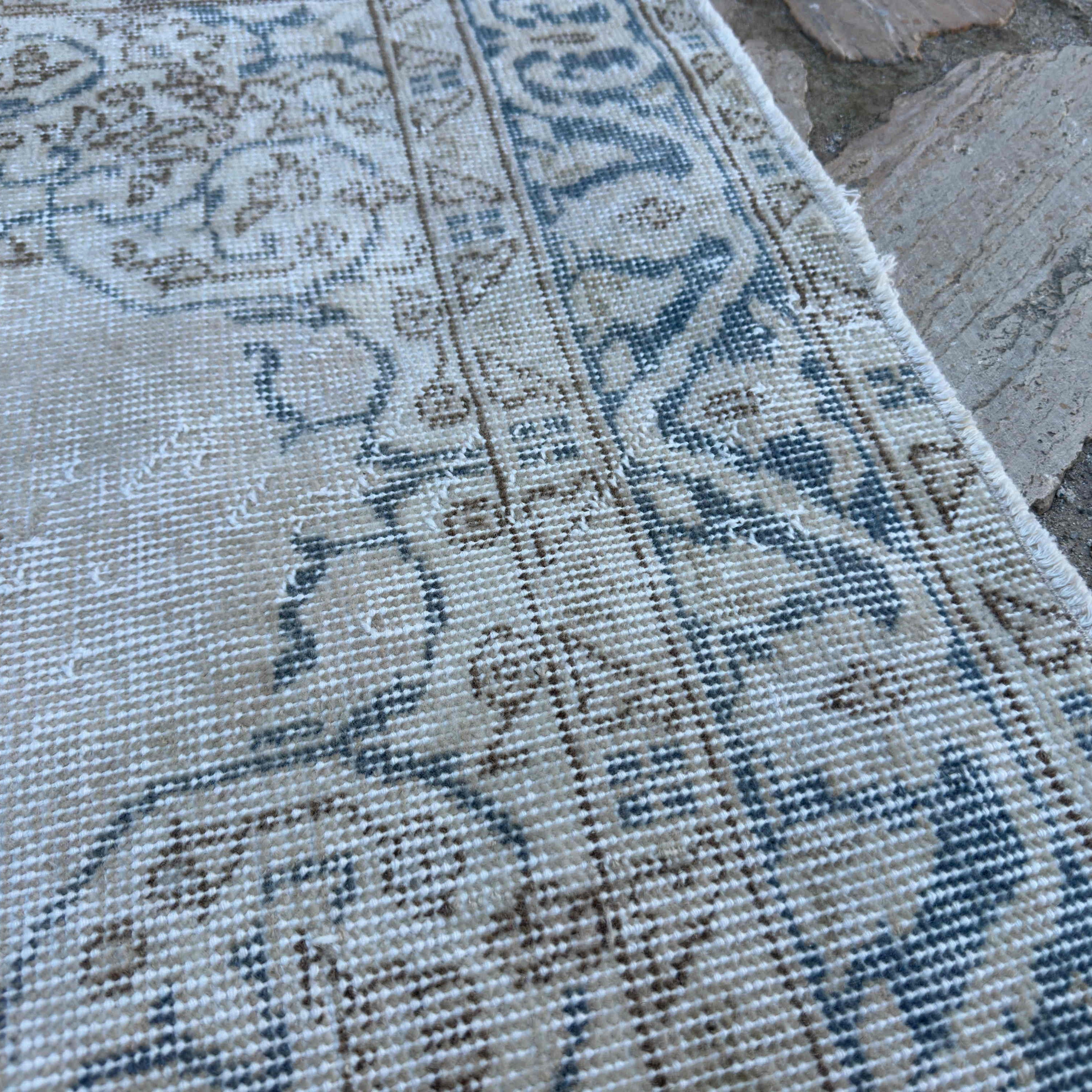 Close-up of the blue vintage turkish rug showing medallion details, hand-knotted weave, wool and cotton and low pile.