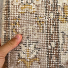 Close-up of the brown vintage turkish rug showing floral details, hand-knotted weave, wool and cotton and low pile.