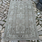 Gray 4' x 7' vintage turkish rug in wool and cotton, shown on the floor.