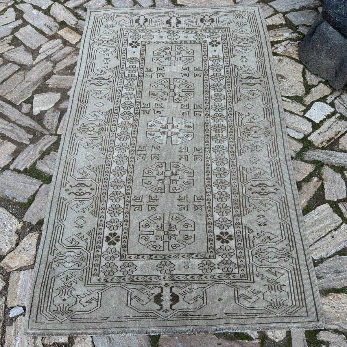 Gray 4' x 7' vintage turkish rug in wool and cotton, shown on the floor.