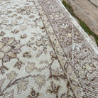 Close-up of the pale pink vintage turkish rug showing floral details, hand-knotted weave, wool and cotton and low pile.