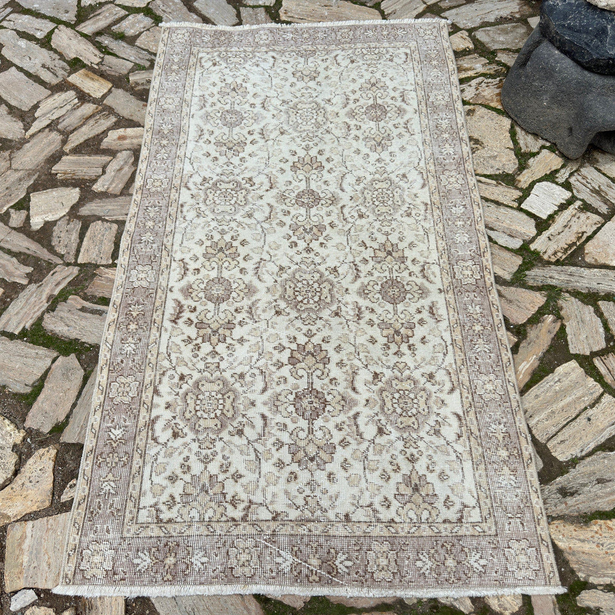 Pale Pink 4' x 7' vintage turkish rug in wool and cotton, shown on the floor.
