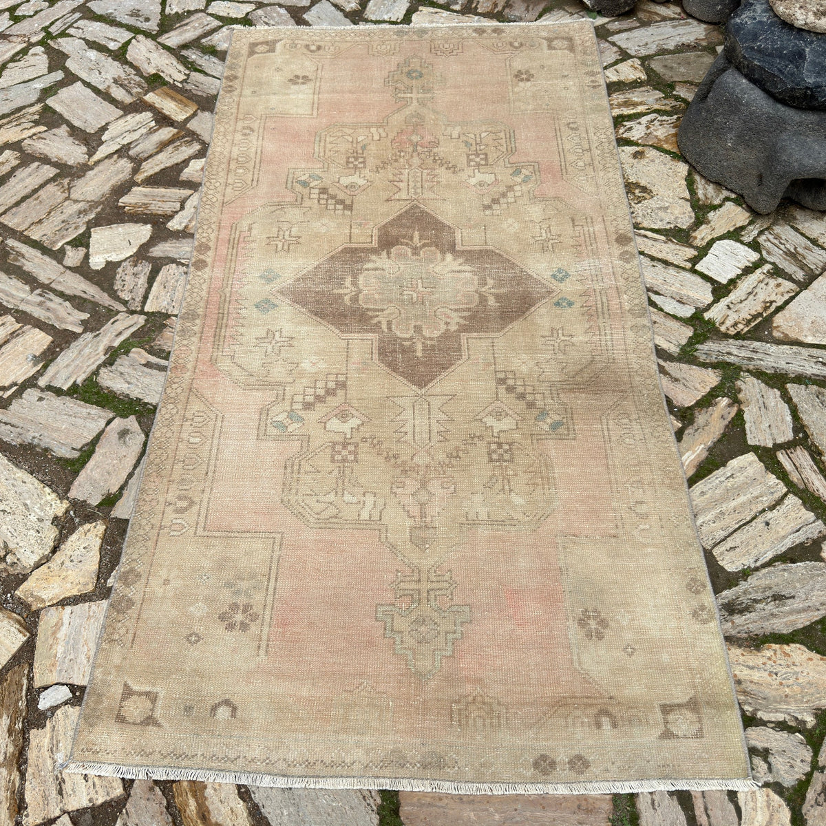 Pale Pink 4' x 7' vintage turkish rug in wool and cotton, shown on the floor.