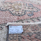 Close-up of the pale pink vintage turkish rug showing traditional details, hand-knotted weave, wool and cotton and low pile.