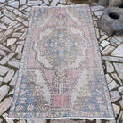 Pale Pink 4' x 7' vintage turkish rug in wool and cotton, shown on the floor.