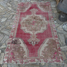 Pale Red 4' x 7' vintage turkish rug in wool and cotton, shown on the floor.