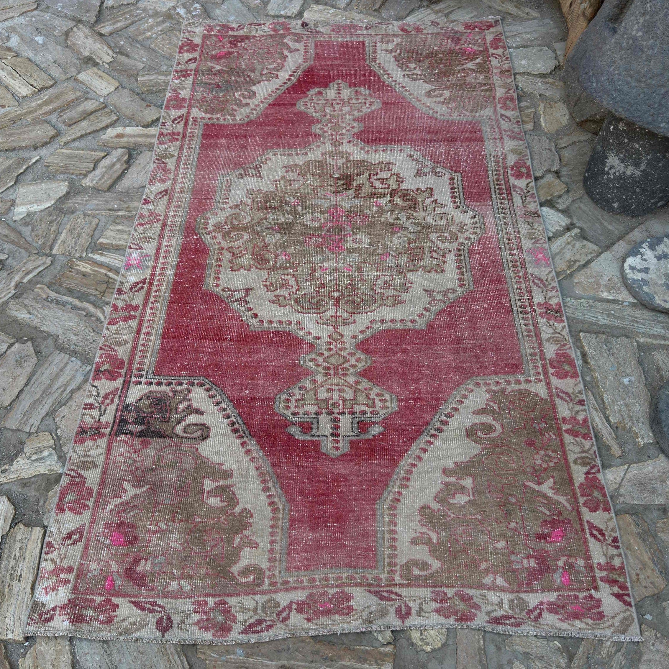 Pale Red 4' x 7' vintage turkish rug in wool and cotton, shown on the floor.