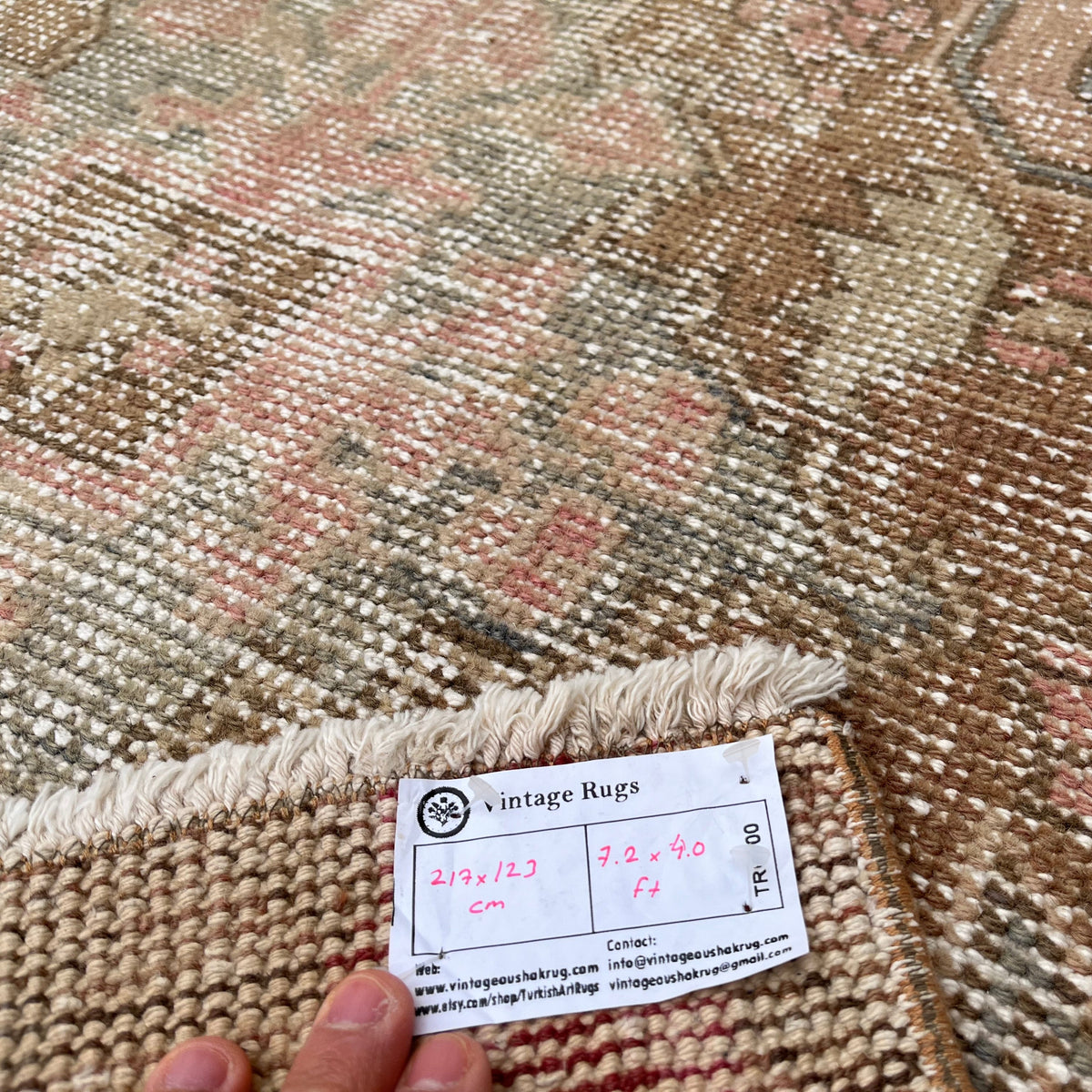 Close-up of the pink vintage turkish rug showing traditional details, hand-knotted weave, wool and cotton and low pile.