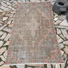 Pink 4' x 7' vintage turkish rug in wool and cotton, shown on the floor.