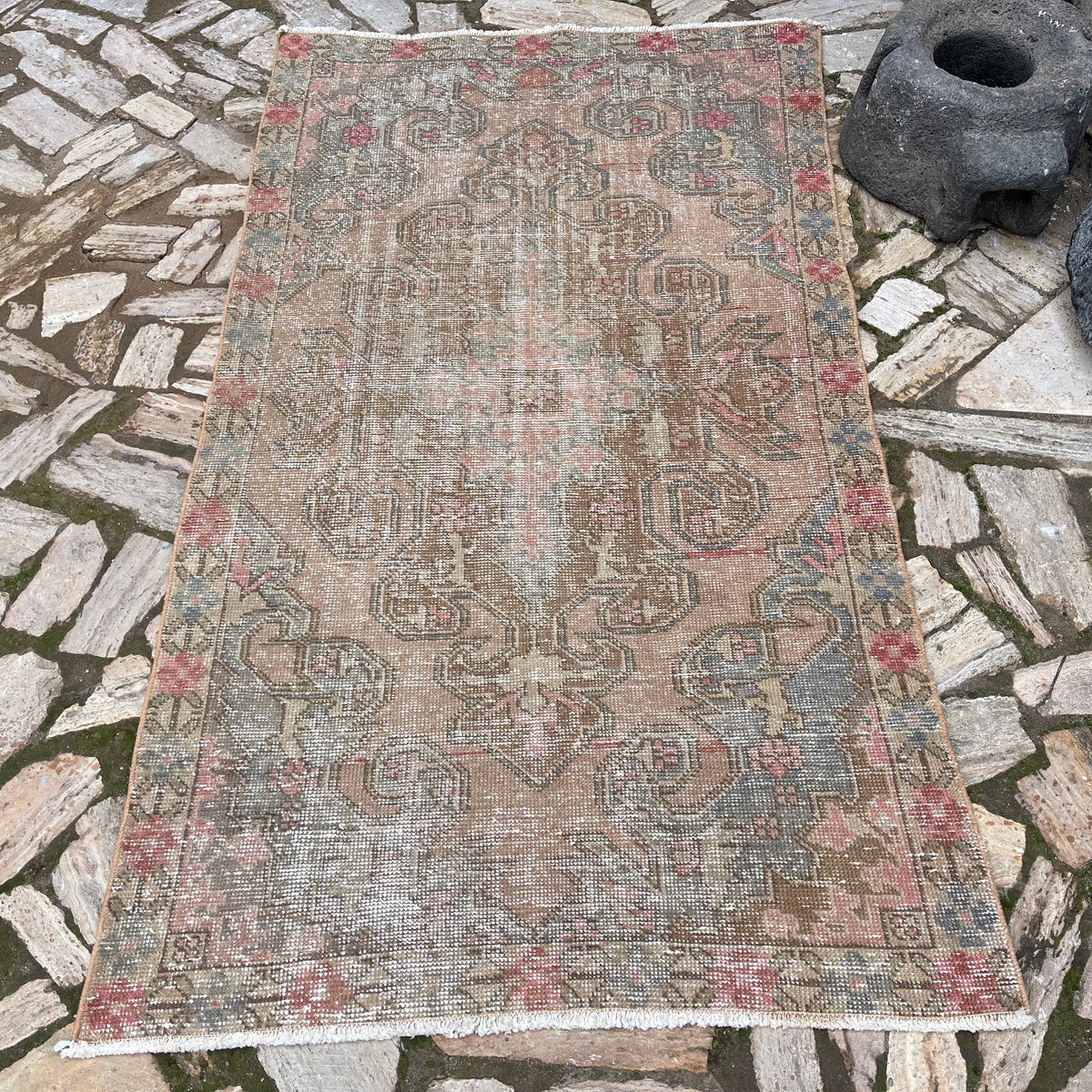 Pink 4' x 7' vintage turkish rug in wool and cotton, shown on the floor.