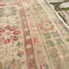 Close-up of the pink vintage turkish rug showing medallion details, hand-knotted weave, wool and cotton and low pile.