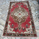 Red 4' x 7' vintage turkish rug in wool and cotton, shown on the floor.