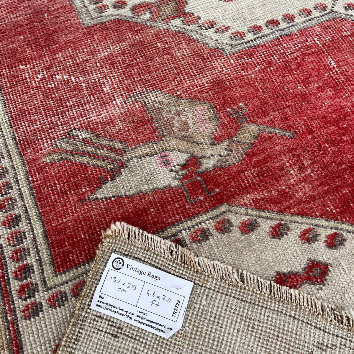 Close-up of the red vintage turkish rug showing traditional details, hand-knotted weave, wool and cotton and low pile.