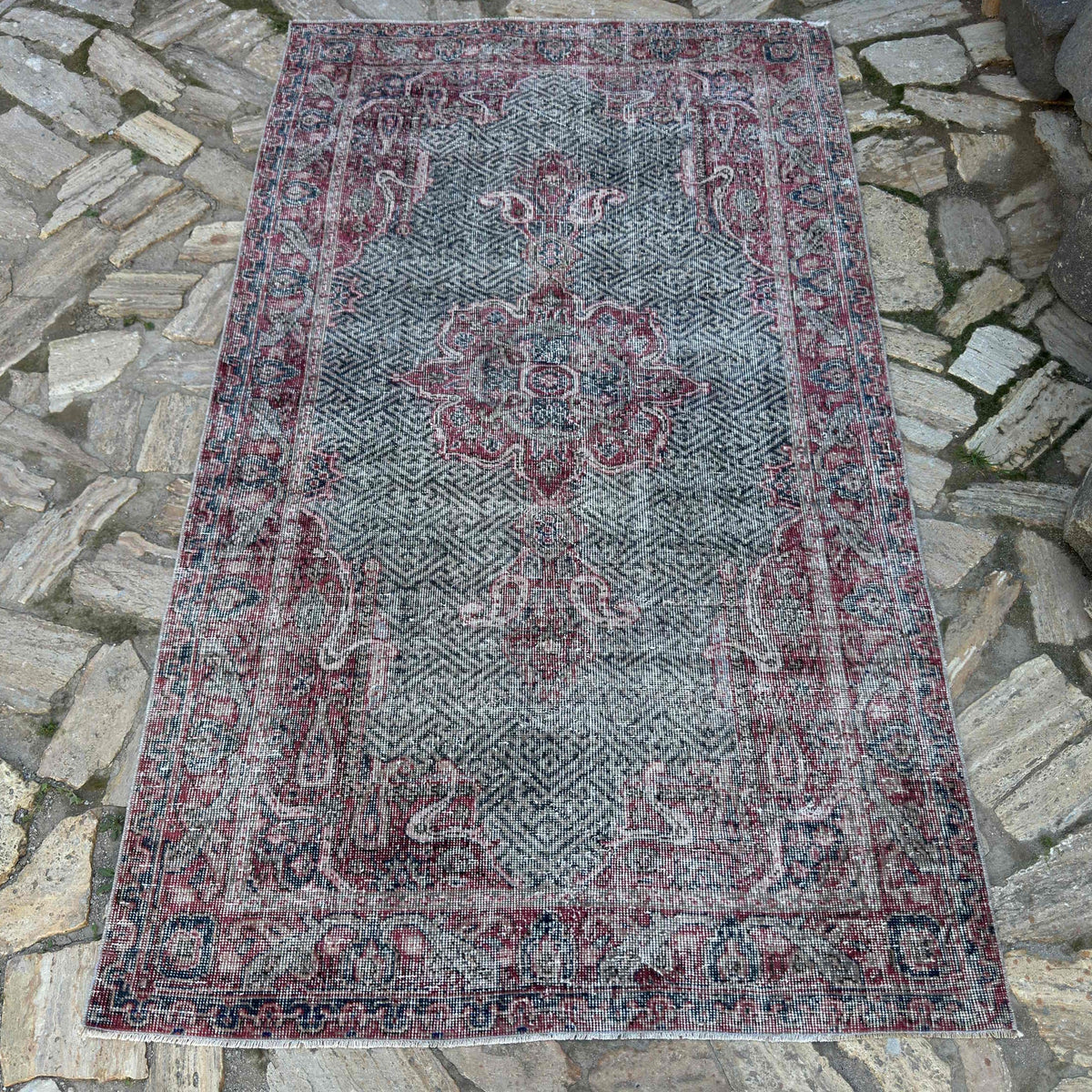 Red 4' x 7' vintage turkish rug in wool and cotton, shown on the floor.