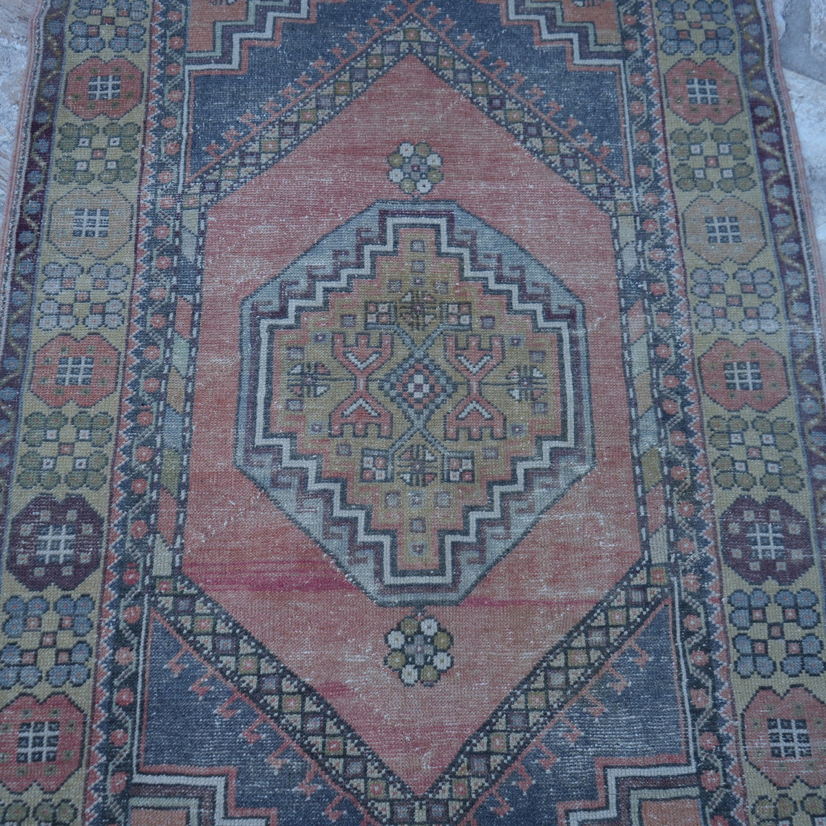 Close-up of the red vintage turkish rug showing traditional details, hand-knotted weave, wool and low pile.