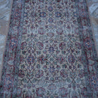 Close-up of the red vintage turkish rug showing floral details, hand-knotted weave, wool and cotton and low pile.