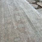 Close-up of the beige vintage turkish rug showing neutral details, hand-knotted weave, wool and cotton and low pile.