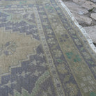 Close-up of the beige vintage turkish rug showing traditional details, hand-knotted weave, wool and cotton and low pile.