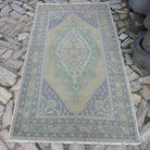 Beige 4' x 8' vintage turkish rug in wool and cotton, shown on the floor.