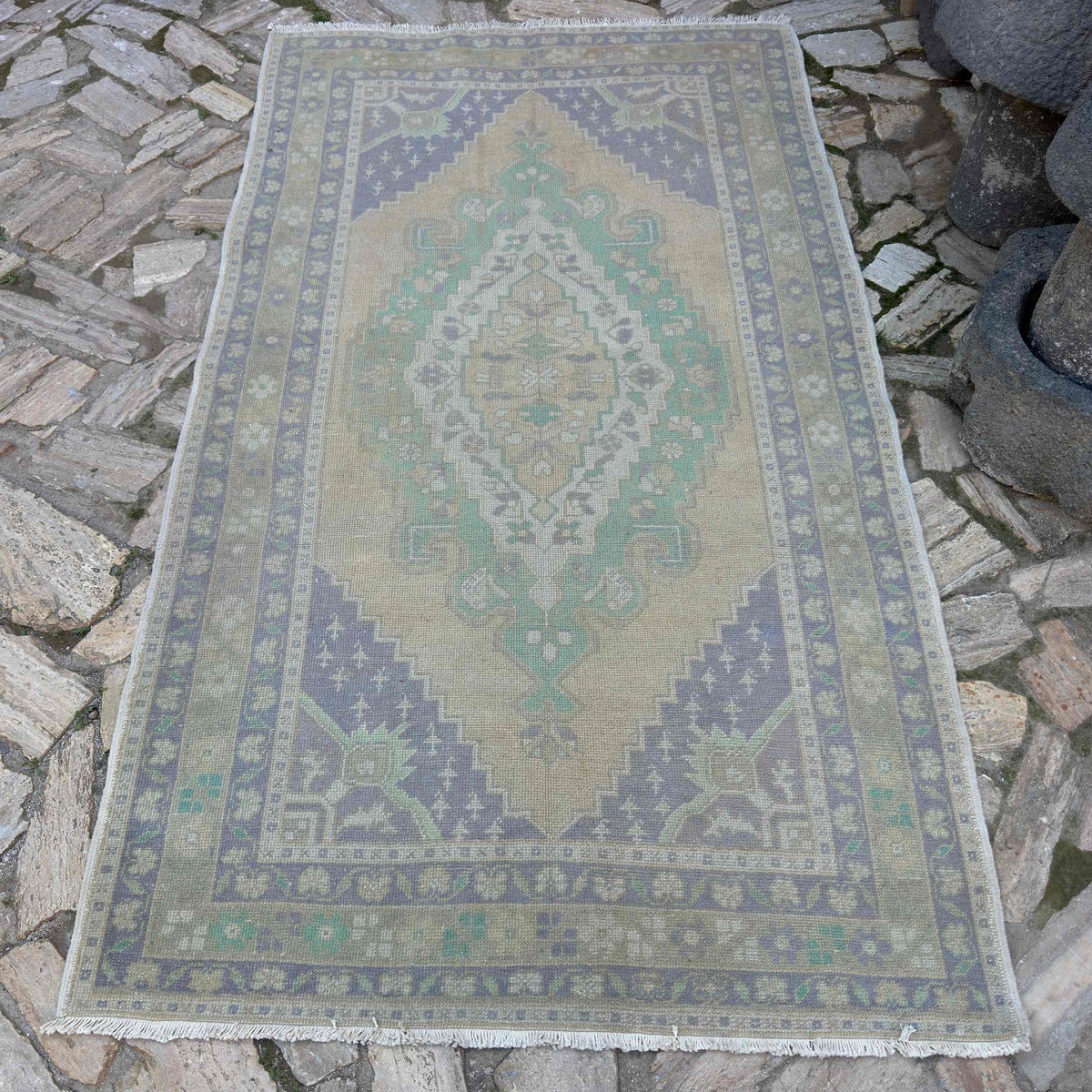 Beige 4' x 8' vintage turkish rug in wool and cotton, shown on the floor.