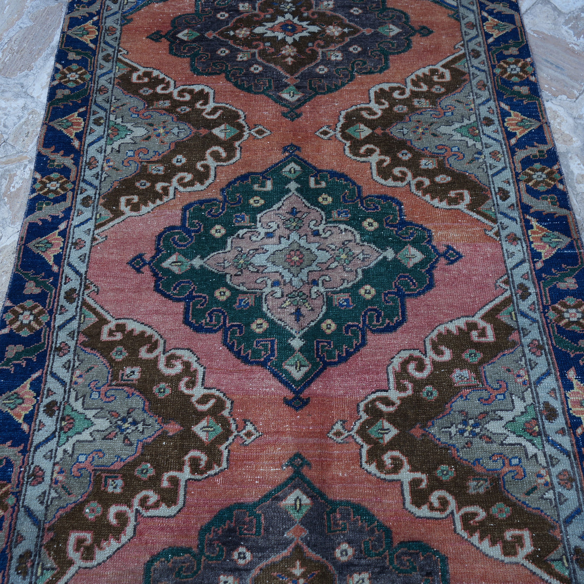 Close-up of the orange vintage turkish rug showing traditional details, hand-knotted weave, wool and cotton and low pile.