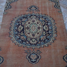 Close-up of the orange vintage turkish rug showing geometric details, hand-knotted weave, wool and cotton and low pile.