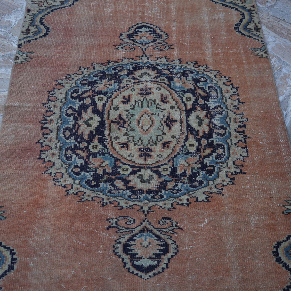 Close-up of the orange vintage turkish rug showing geometric details, hand-knotted weave, wool and cotton and low pile.
