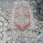 Pale Pink 4' x 8' vintage turkish rug in wool and cotton, shown on the floor.