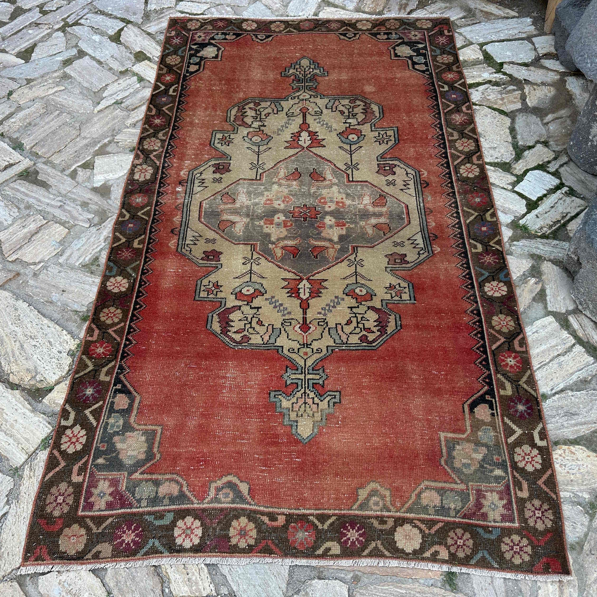 Pale Red 4' x 8' vintage turkish rug in wool and cotton, shown on the floor.