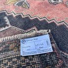 Close-up of the pale red vintage turkish rug showing traditional details, hand-knotted weave, wool and cotton and low pile.