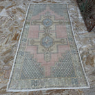 Close-up of the pink vintage turkish rug showing traditional details, hand-knotted weave, wool and cotton and low pile.