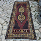 Red 4' x 8' vintage turkish rug in wool and cotton, shown on the floor.