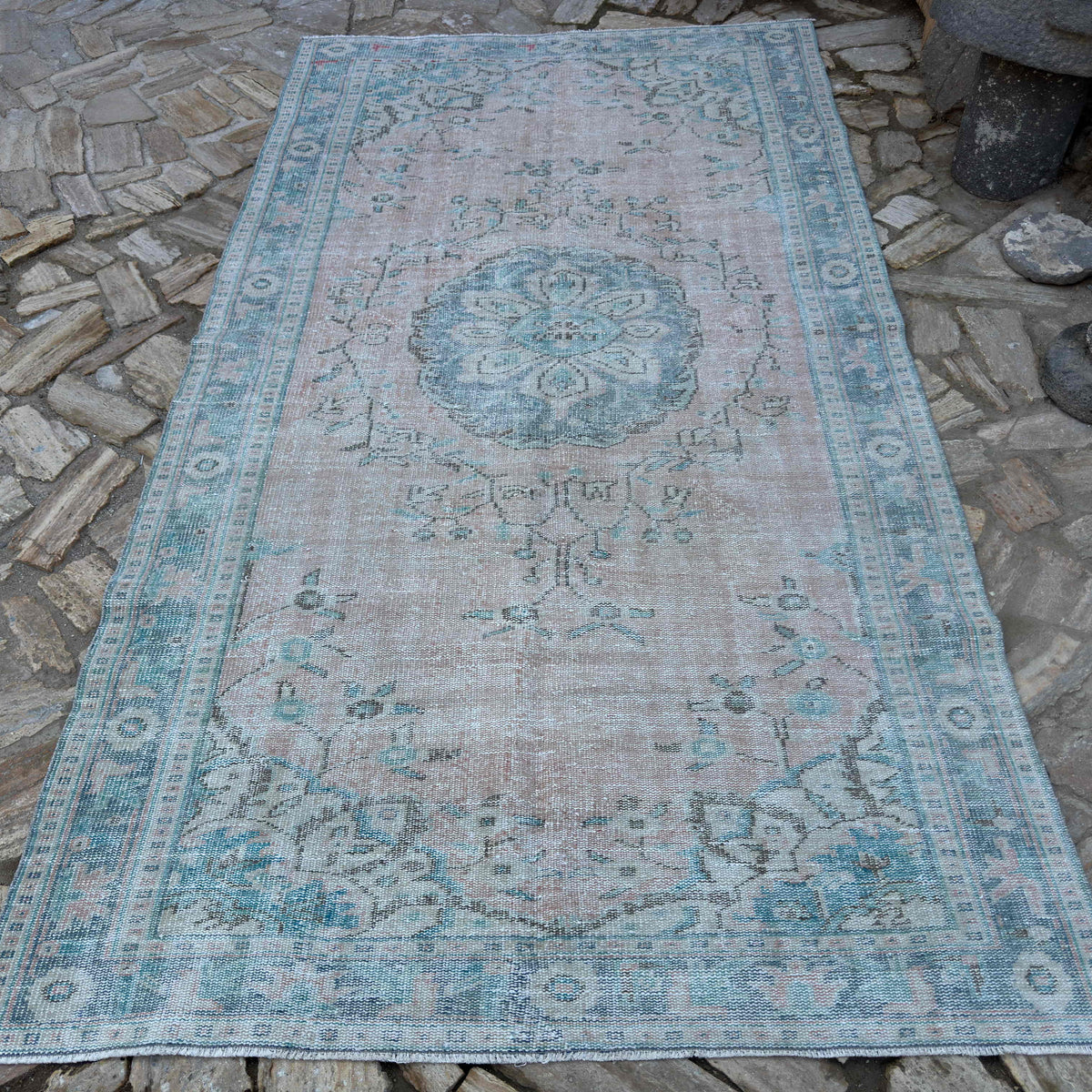 Pink 5' x 10' vintage turkish rug in wool and cotton, shown on the floor.